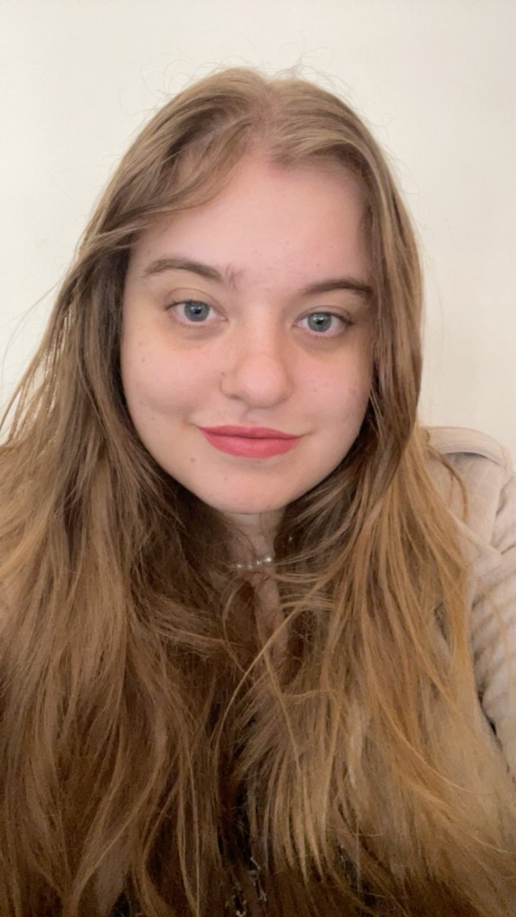 Foto de Júlia Di Simoni Araújo, psicóloga sorrindo de forma acolhedora